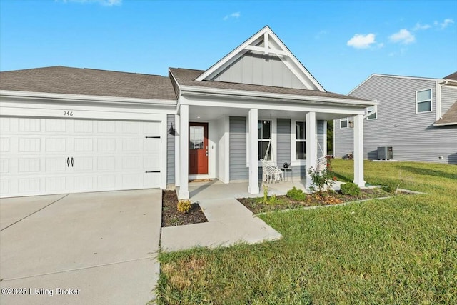 view of front of home with covered porch, a front yard, and a garage