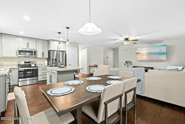 dining room with ceiling fan and dark hardwood / wood-style flooring