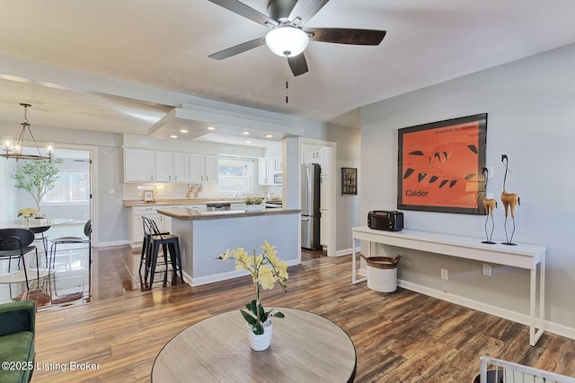 living room featuring hardwood / wood-style floors and ceiling fan with notable chandelier