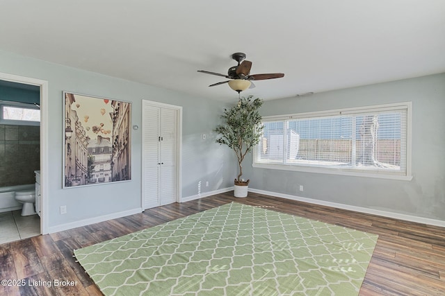 empty room featuring dark wood-type flooring and ceiling fan