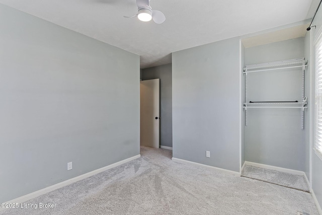 unfurnished bedroom with ceiling fan, light carpet, and a closet