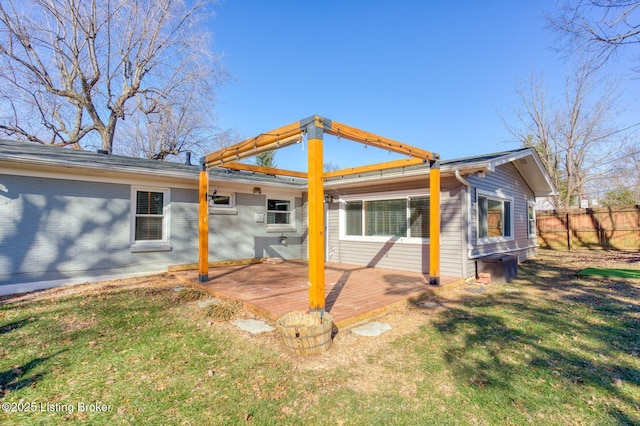 rear view of property with a deck and a lawn