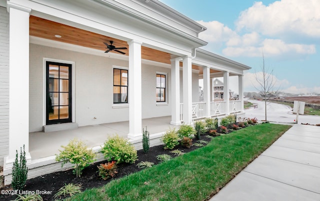 entrance to property with covered porch and ceiling fan