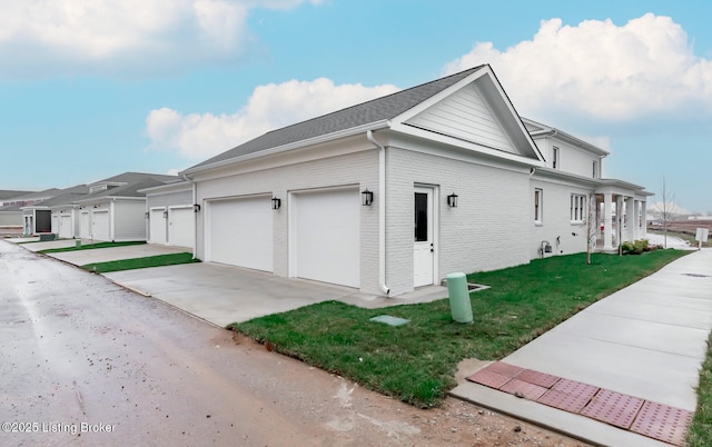 view of side of home featuring a lawn and a garage