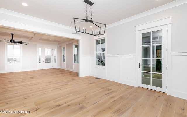 unfurnished dining area featuring coffered ceiling, ceiling fan with notable chandelier, crown molding, light hardwood / wood-style floors, and beam ceiling