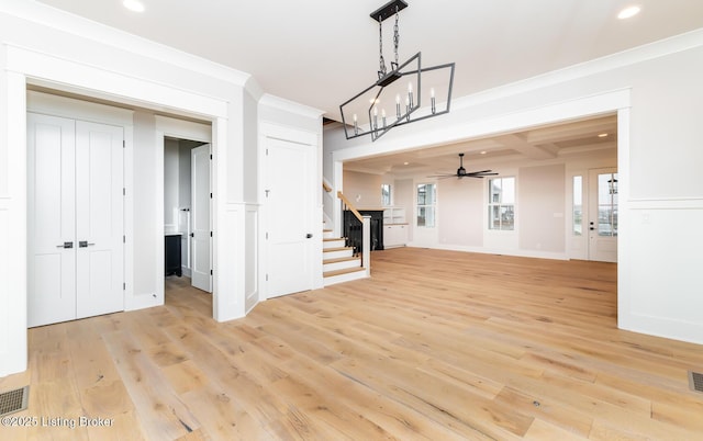 unfurnished living room featuring coffered ceiling, light hardwood / wood-style flooring, ceiling fan, ornamental molding, and beamed ceiling