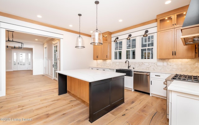 kitchen featuring a kitchen island, light stone counters, stainless steel dishwasher, decorative light fixtures, and white cabinets