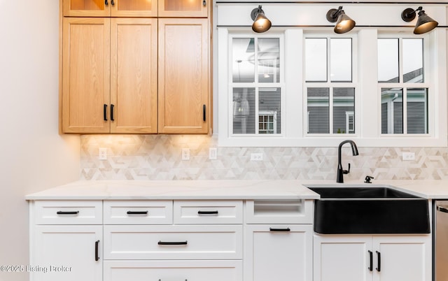 kitchen with decorative backsplash, white cabinets, and sink