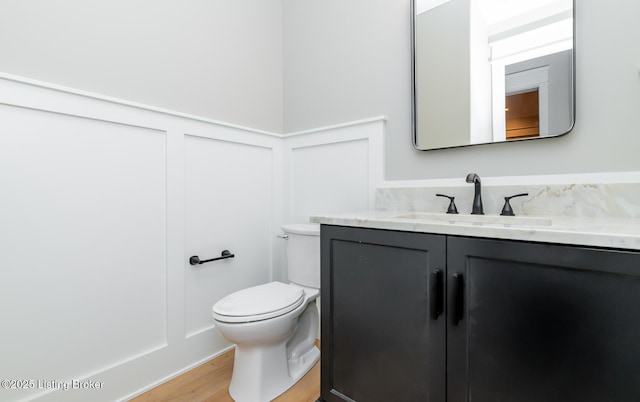 bathroom featuring wood-type flooring, vanity, and toilet