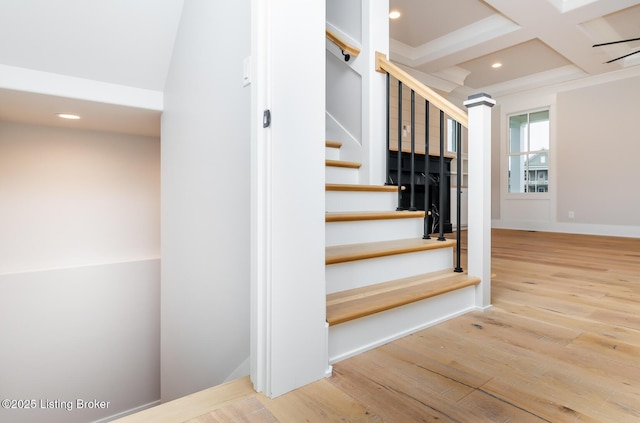 stairway featuring beamed ceiling, wood-type flooring, and coffered ceiling