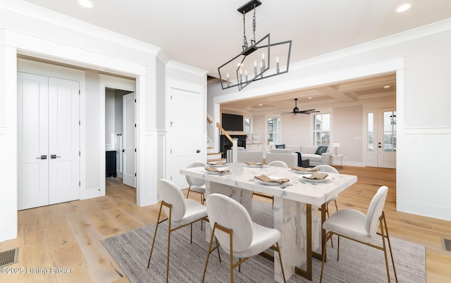 dining space with beam ceiling, ceiling fan, coffered ceiling, crown molding, and light hardwood / wood-style floors