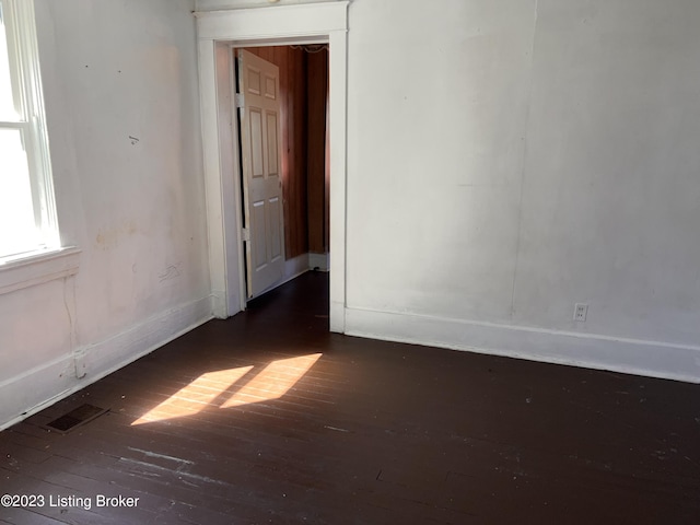 empty room with dark hardwood / wood-style flooring