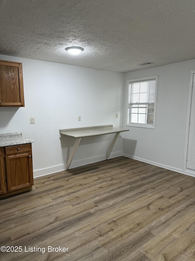 interior space featuring a textured ceiling and light wood-type flooring