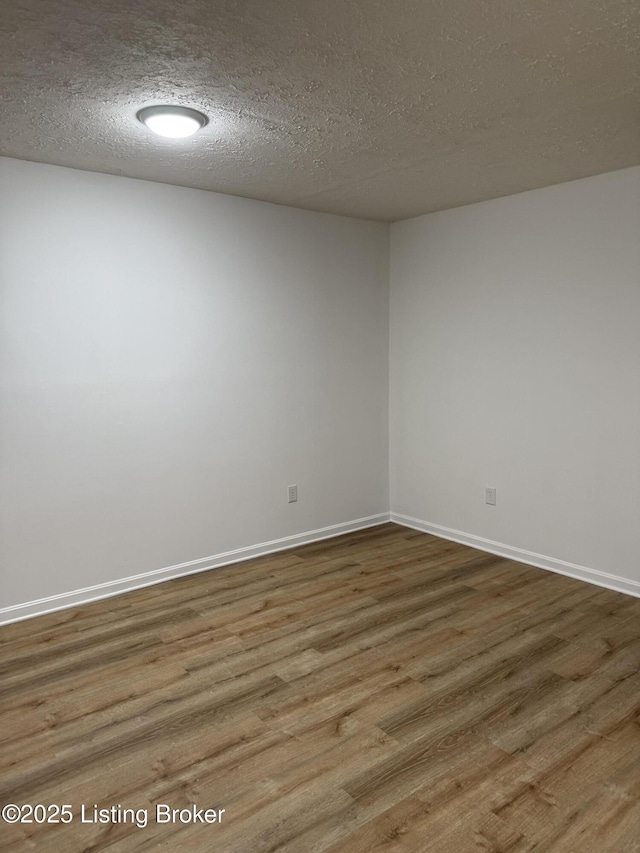 empty room featuring a textured ceiling and hardwood / wood-style flooring