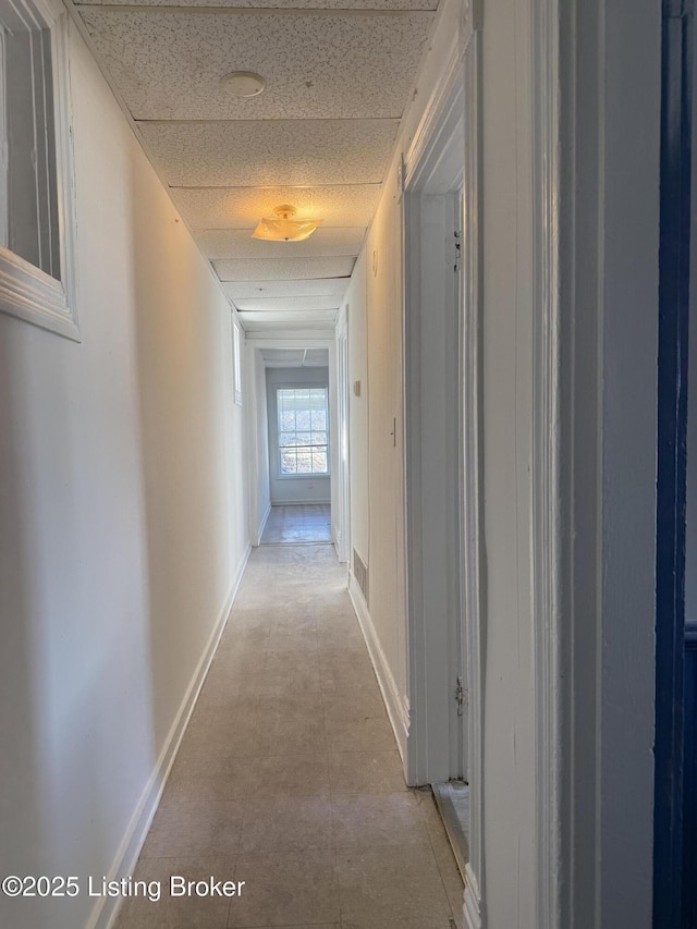 corridor with a paneled ceiling