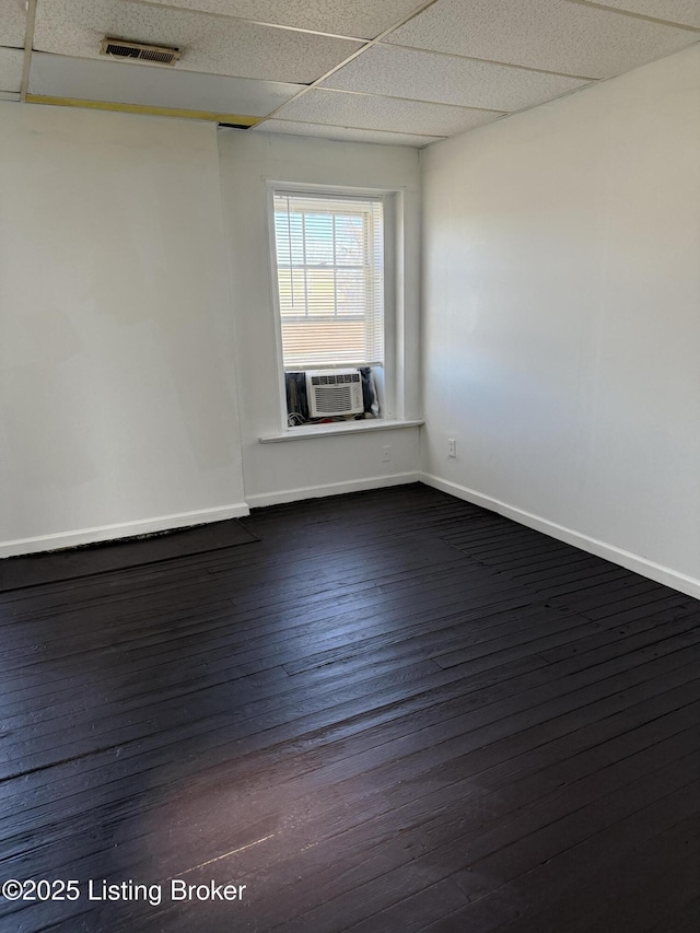 spare room with cooling unit, a paneled ceiling, and dark hardwood / wood-style floors