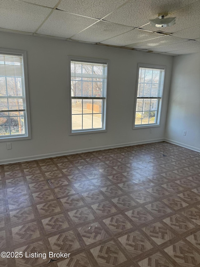 empty room with parquet floors and a drop ceiling