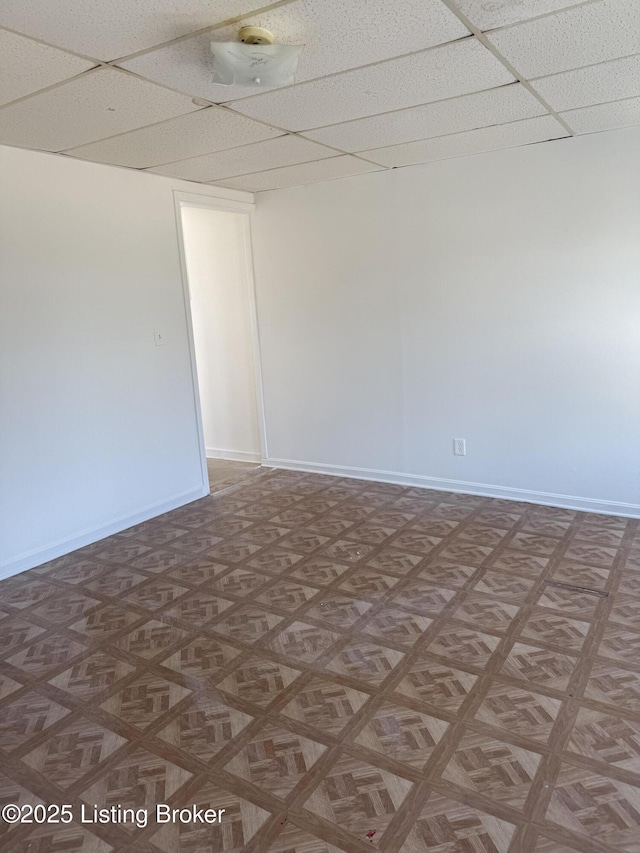 spare room featuring a paneled ceiling and parquet flooring