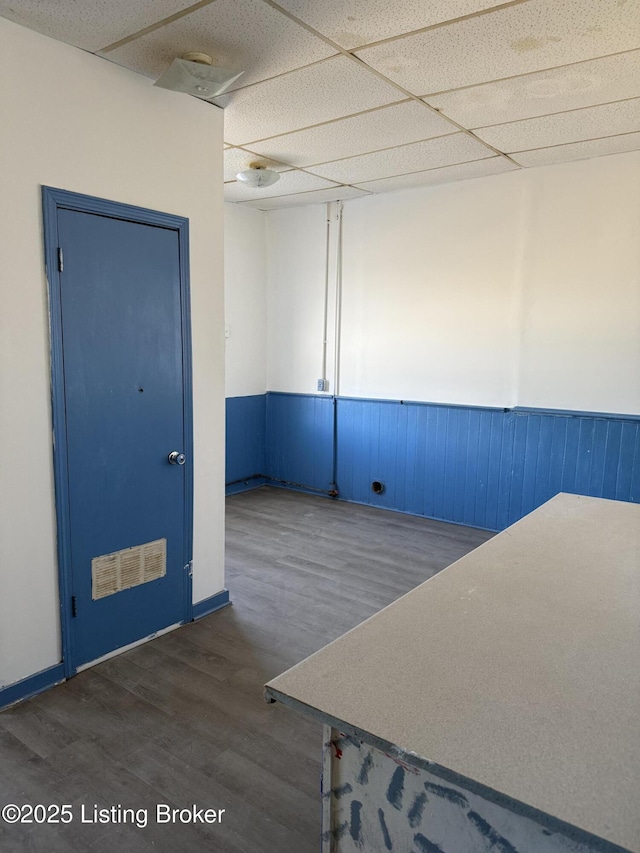 spare room with dark hardwood / wood-style flooring and a paneled ceiling