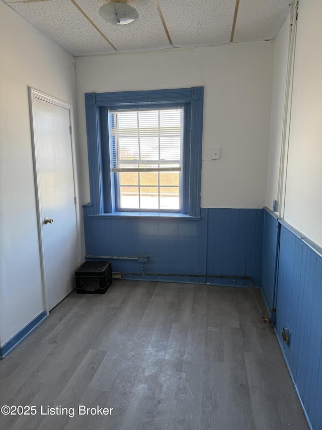 spare room featuring hardwood / wood-style floors and a drop ceiling