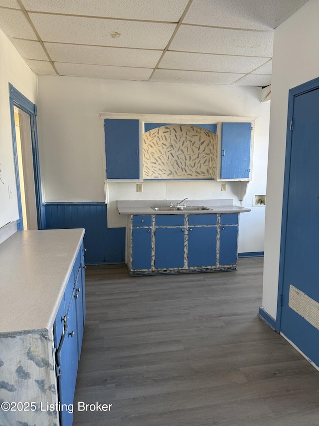 kitchen with a drop ceiling, sink, and blue cabinets