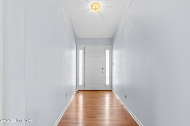 doorway to outside featuring light hardwood / wood-style floors and a textured ceiling