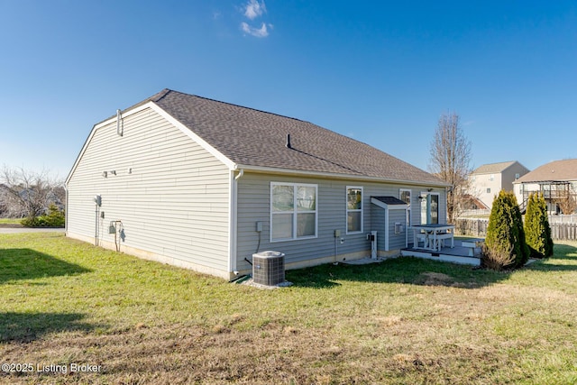 rear view of property with a lawn and central AC