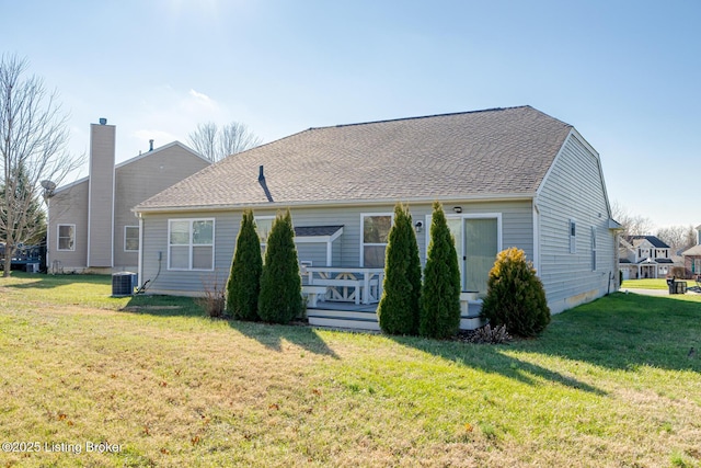 back of property featuring central AC unit, a deck, and a yard