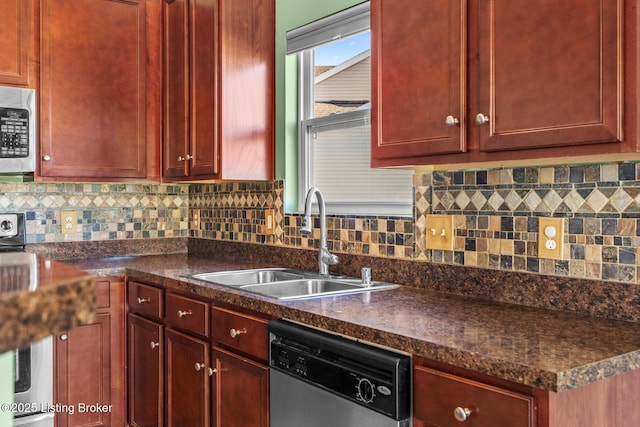 kitchen with backsplash, appliances with stainless steel finishes, sink, and a skylight