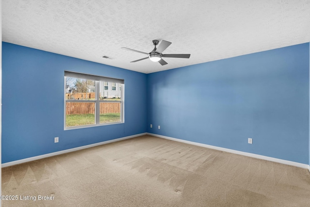 carpeted empty room featuring a textured ceiling and ceiling fan