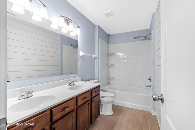 full bathroom with a textured ceiling, shower / tub combination, vanity, and toilet