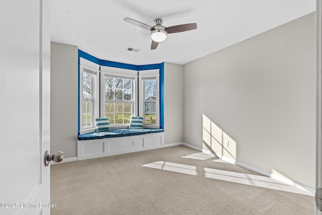 carpeted spare room featuring ceiling fan and a textured ceiling