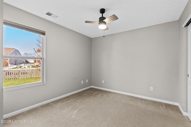 carpeted spare room with ceiling fan