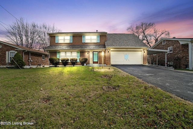 front of property with a lawn and a garage