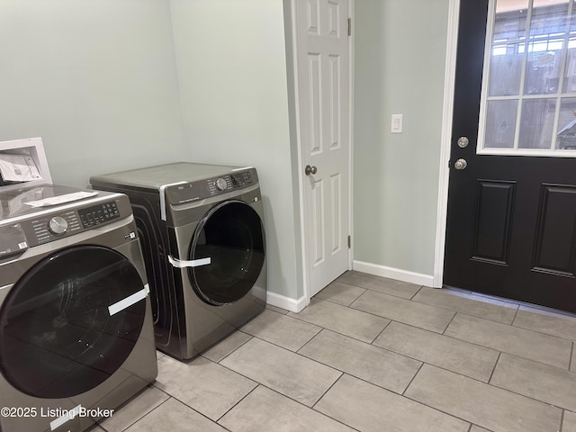 clothes washing area with light tile patterned floors and washing machine and clothes dryer