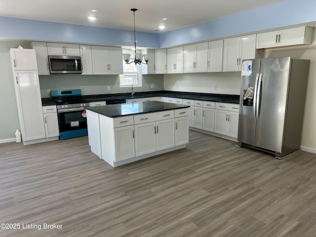 kitchen with pendant lighting, white cabinets, and appliances with stainless steel finishes