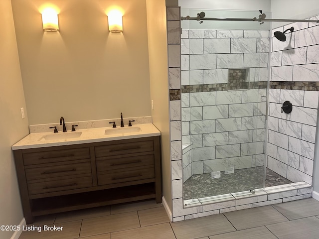 bathroom with a tile shower and vanity