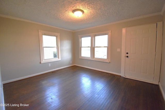 unfurnished room with a healthy amount of sunlight, a textured ceiling, ornamental molding, and dark wood-type flooring