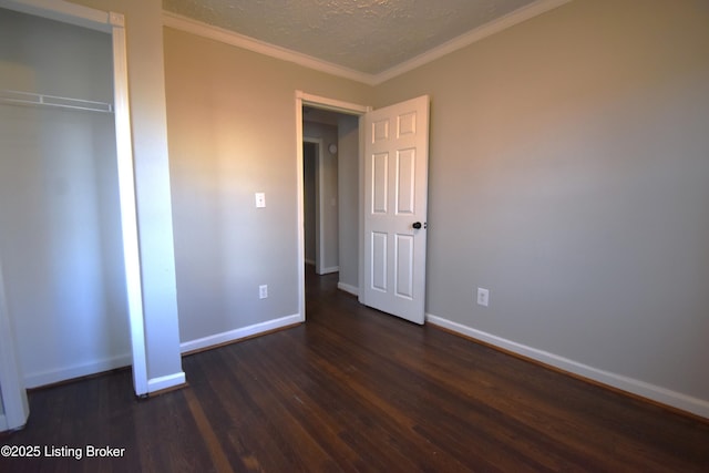 unfurnished bedroom featuring a textured ceiling, dark hardwood / wood-style flooring, a closet, and ornamental molding