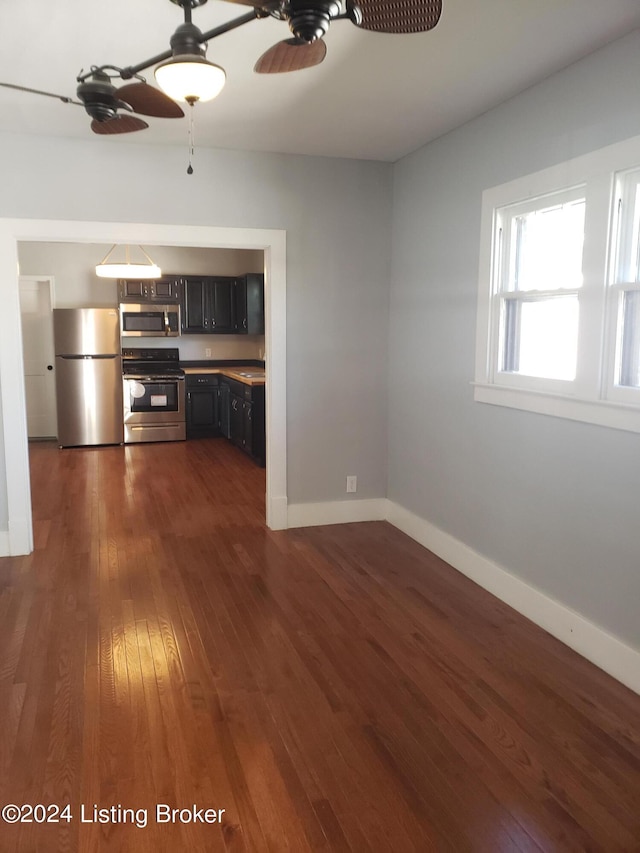 unfurnished living room with ceiling fan and dark wood-type flooring