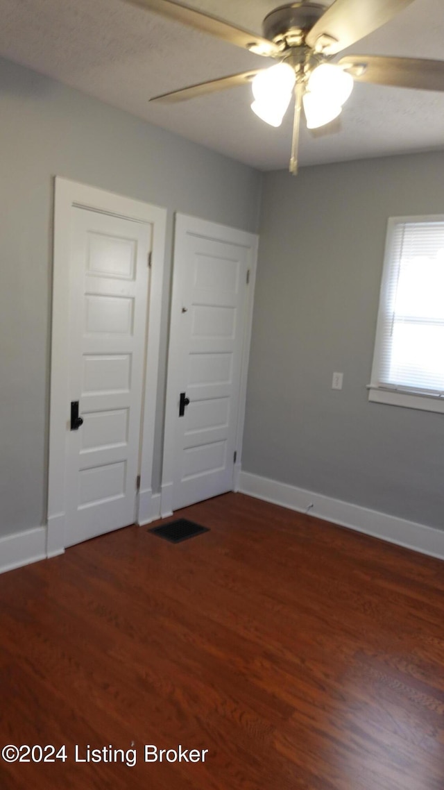 spare room featuring dark hardwood / wood-style floors and ceiling fan