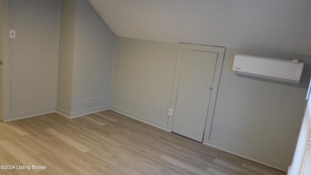 bonus room featuring light hardwood / wood-style floors and a wall mounted AC