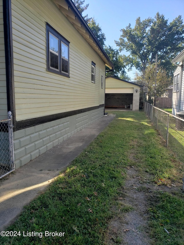 view of side of home with a yard, a garage, and an outdoor structure