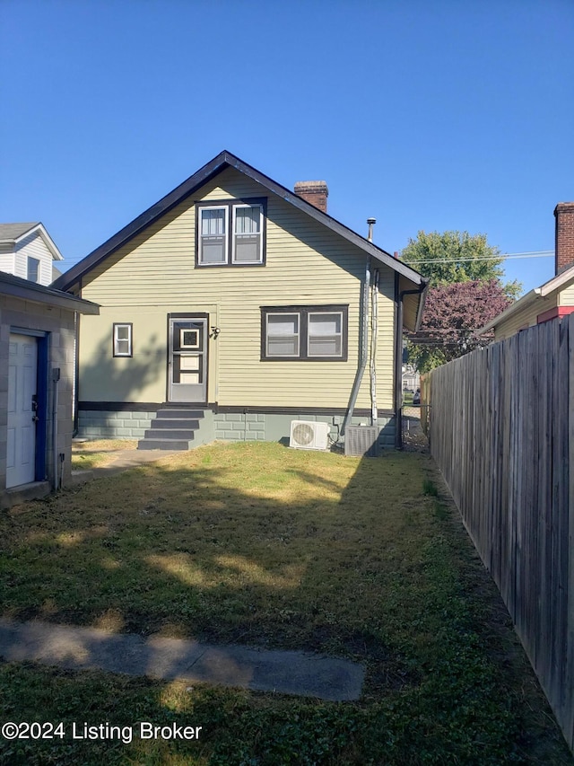 view of front of house with ac unit and a front lawn