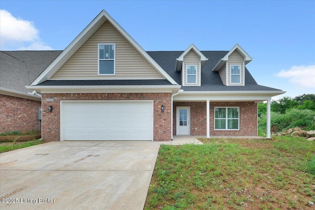 view of front of house with covered porch, a garage, and a front lawn