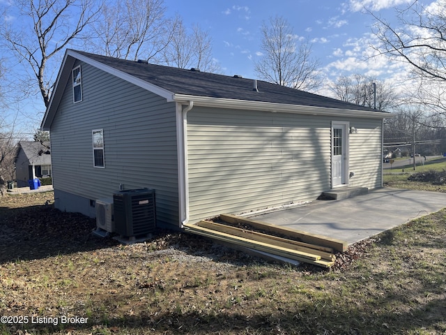 view of side of home with central AC unit and a patio area