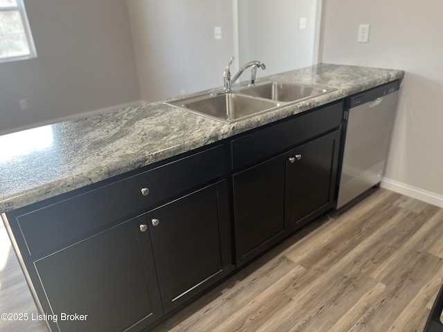 kitchen with dishwasher, light hardwood / wood-style flooring, and sink