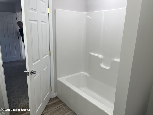 bathroom featuring hardwood / wood-style floors and  shower combination