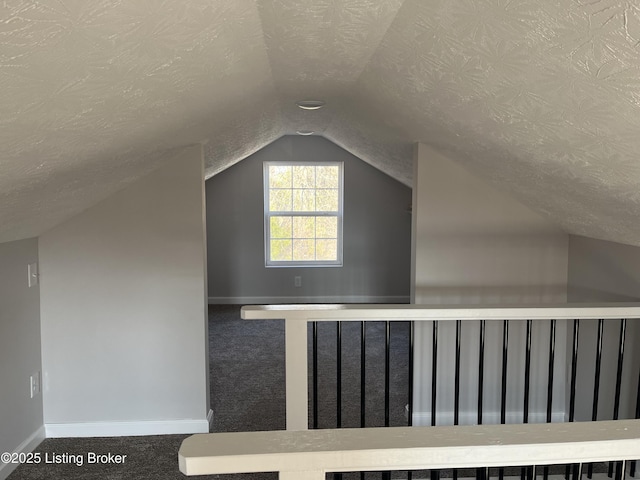 bonus room with a textured ceiling, carpet floors, and vaulted ceiling