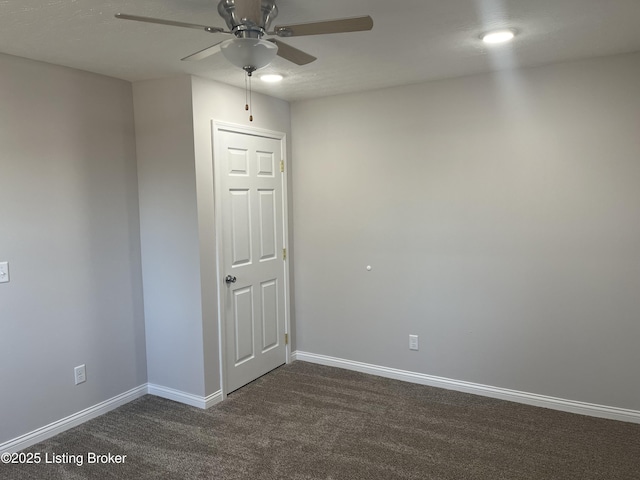 unfurnished room with dark colored carpet and ceiling fan